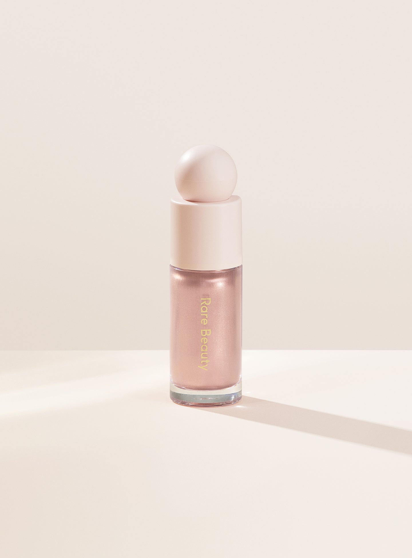 Enchant| Rare Beauty's Positive Light Liquid Luminizer in the soft pink shade "Enchant."