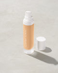 open bottle of Fenty Beauty Pro Filt'r Soft Matte Longwear Foundation with pump dispenser in shade #210 on concrete background