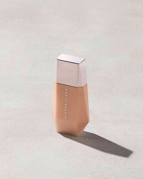 Eaze Drop’Lit All-Over Glow Enhancer shown in shade Honey Citrine on a concrete background. 